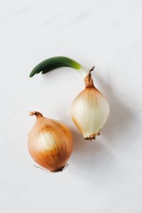 Kaboompics - Single Yellow Onion with Green Sprout on White for Recipe Branding