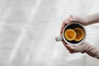 Kaboompics - Hands Holding a Cup of Orange Tea