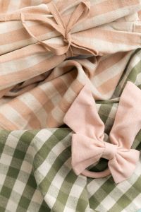 Kaboompics - Pastel Fabric Bow On Green Gingham And Striped Textile