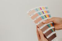 Kaboompics - Interior designer working on architecture plans on her computer and looking at color palettes - brown - beige - Pantone