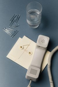 Kaboompics - Blue Office Desk Still Life with Telephone Receiver, Glass and Scattered Paper Clips