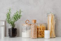 Kaboompics - Rosemary and Glass Jars of Flour, Chickpeas and Pasta on a White Kitchen Counter