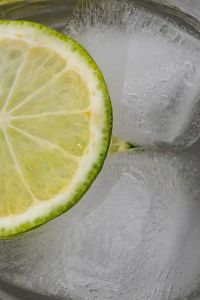 Kaboompics - Large Lime Wheel and Ice Cubes in Clear Water, Vertical Macro Citrus Detox Drink Background