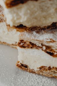 Kaboompics - Vertical Close-Up of Flaky Napoleonka Pastry and Whipped Cream Layers