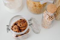 Kaboompics - Overhead Glass Jars of Chocolate Chip Cookies and Chickpeas on a White Counter