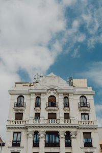 Kaboompics - Vertical Madrid View of Ornate White Facade and Balconies Beneath Cloudy Blue Sky