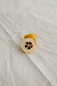 Kaboompics - Single Japanese Quince Cross-Section on Rumpled Linen, Minimal Macro Food Background