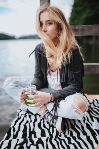 Kaboompics - Blonde woman having a healthy snack at the wooden pier