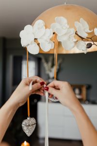 Kaboompics - A woman hangs Christmas decorations