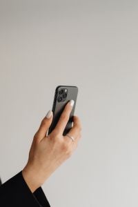 Kaboompics - Hand Holding a Smartphone Against a Minimalist Background