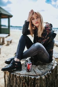 Kaboompics - Woman Relaxing Cross Legged on a Beach Stump with Coke Can