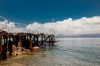Kaboompics - Wide Wooden Pier with White Railings over Calm Sea Beneath Summer Clouds