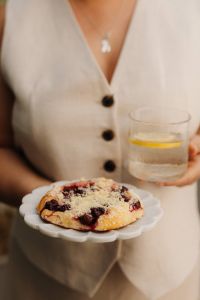 Kaboompics - Person Holding a Plate with Cherry Pastry and Lemon Water