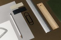 Kaboompics - Office Desk Styling with Color Swatches, Rulers, Pencil and Black Binder Clip on Brown Background