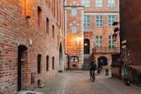 Kaboompics - Cyclists Crossing a Brick-Lined Courtyard in Gdańsk Old Town