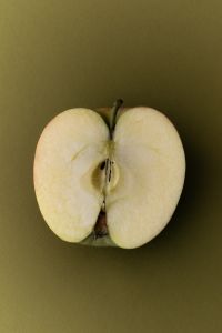 Kaboompics - Halved Apple on Olive Green Background