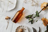Kaboompics - Dried Roses and Amber Glass on Linen for Rustic Botanical Backgrounds