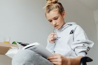Kaboompics - Teenager Studying with Book and Glasses