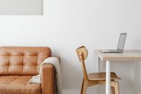 Kaboompics - Laptop on a Light Wood Desk Beside a Tan Leather Sofa, Modern Home Office Content