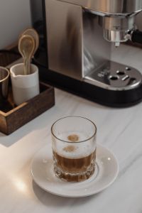 Kaboompics - Layered Coffee Glass on White Saucer Beside Coffee Machine