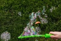 Kaboompics - Hand Holding Green Bubble Wand Creating a Triangular Bubble Film