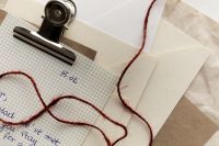 Kaboompics - Handwritten Letter on Grid Paper with Envelopes and Red String