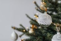 Kaboompics - White Christmas Bauble with Lace Detail and Tree Bokeh