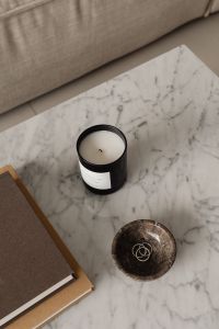 Kaboompics - Black Candle and Gold Rings in Stone Dish by Beige Sofa