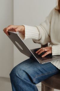 Kaboompics - Faceless Woman in White Sweater Holding Laptop Screen