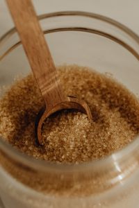 Kaboompics - Macro Brown Sugar Crystals with Wooden Spoon Scoop Inside a Glass Jar, Baking Ingredient Texture