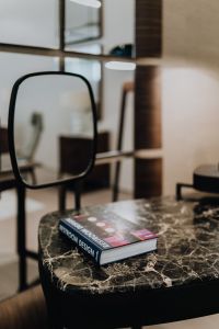 Kaboompics - Black-Framed Mirror and Interior Design Book on Marble Table
