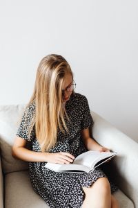 Kaboompics - Teenage Girl Reading Textbook in Armchair