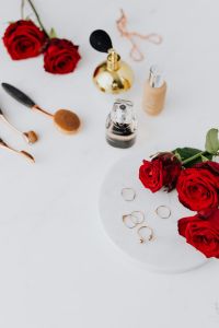 Kaboompics - Red roses, gold rings, perfume brushes and make-up accessories on white marble