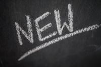Kaboompics - Close-Up of Handwritten NEW with a Chalk Underline, Blackboard Background for Product Launch