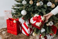 Kaboompics - Hand Placing a Gift Under a Decorated Christmas Tree