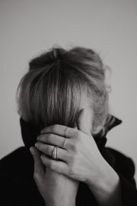 Kaboompics - Black and White Woman Raising Arm Across Face with Necklace