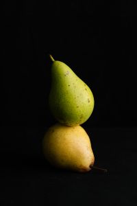 Kaboompics - Two Pears Balanced on Black Background