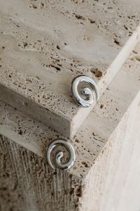 Kaboompics - Silver Spiral Earrings on a Travertine Table Edge