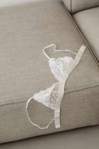 Kaboompics - White Lace Bra Draped over a Sofa