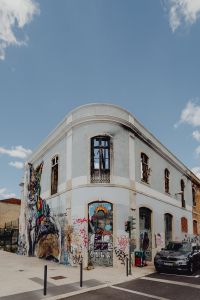 Kaboompics - Graffiti-Covered White Lisbon Corner Facade with Parked Car and Street Art