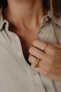 Kaboompics - Woman Adjusting Collar Wearing Gold Rings
