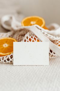 Kaboompics - Close Crop of Orange Slice and Blank Card over Soft Mesh Produce Bag