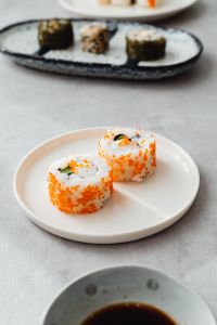Kaboompics - Soft-Focus Sushi Platter with Maki Rolls on Ceramic Plates