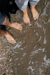 Kaboompics - Bare Feet and Beachgoers Standing in Foamy Shallow Seawater, Overhead View