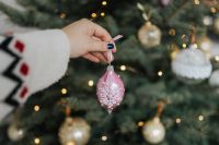 Kaboompics - Hand Holding Pink Snowflake Ornament by Christmas Tree
