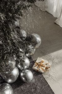 Kaboompics - Silver Balloons and Gold Wrapped Gift beside a Christmas Tree