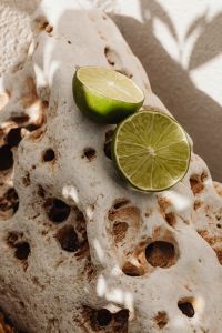 Kaboompics - Lime Halves on Porous Coral Rock and White Pebbles
