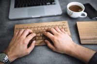 Kaboompics - Young man typing on the wooden keyboard