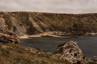Kaboompics - Wide Cove with Eroded Cliffs and Grassy Foreground