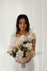 Kaboompics - Bride Admiring a Blush Rose Bouquet by the Window